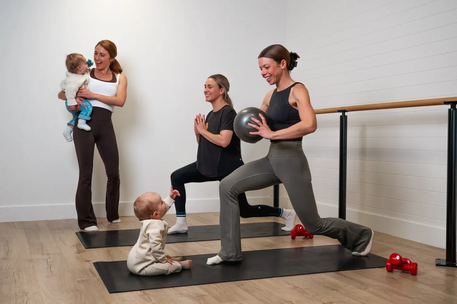 Bridget holding a baby while mums train in the studio
